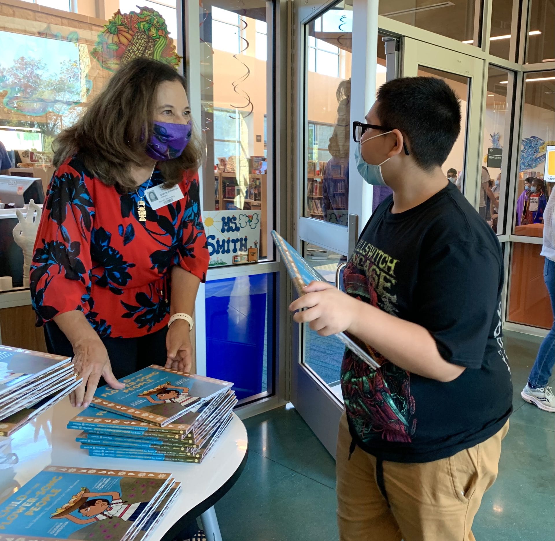 Author, Gloria Amescua, greeting student